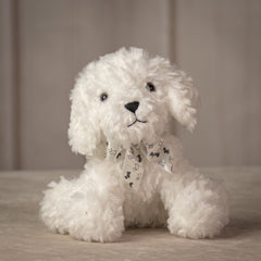 Small sitting white dog with white bow