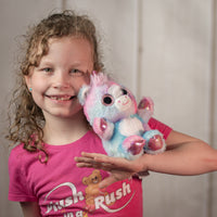 girl holding 6.5" rainbow Dazzle Unicorn Duo with sparkle eyes and iridescent horn and hands and feet 