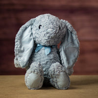 16 in stuffed blue bunny wearing a bow and has striped ears