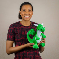 A woman holds a green dragon that is 10 inches tall while sitting