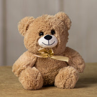A beige bear that is 10 inches tall while sitting wearing a matching bow