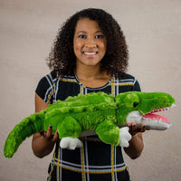 A woman holds a green alligator that 26 inches from head to tail