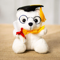 A white bear that is 6 inches tall while sitting wearing a graduation hat and glasses and holding a diploma 