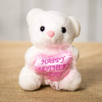 A white bear that are 6 inches tall while sitting holding a pink heart that says "Happy Mothers Day"