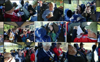 A smiling Veteran on the Honor Flight proudly holding a small eagle plush toy during the trip