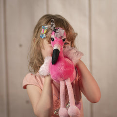 Little girl holding a 14 inch sitting pink flamingo with a black and white plaid bow