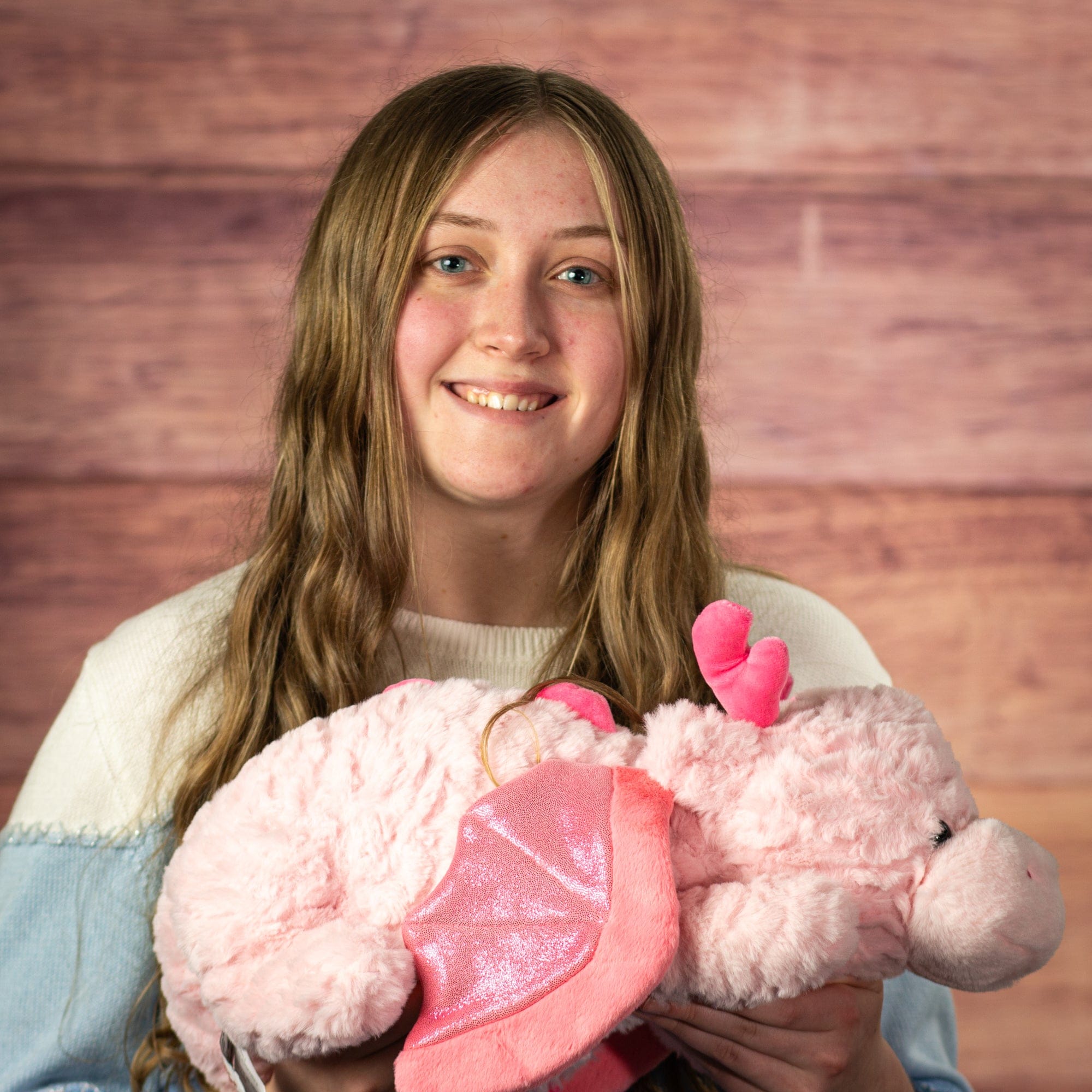 Woman with weighted pink dragon plush toy.