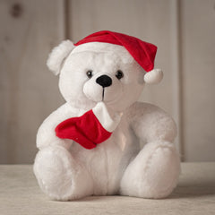 Medium sized white bear wearing a red Santa hat and holding a red stocking
