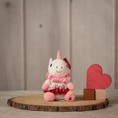 6" stuffed white unicorn keychain with three Valentine's designed hair scrunchies tied around its body