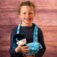 girl holding a stuffed shark in a swaddle