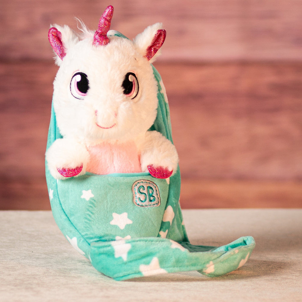 stuffed unicorn with metallic horn in its swaddle 