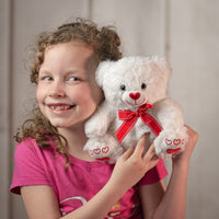 girl holding 8" White Valentine Bear with a red heart now and paws wearing a bow