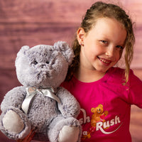 girl holding 10 in grey stuffed teddy bear set wearing a bow