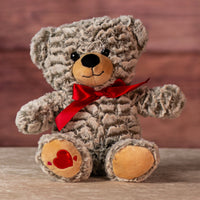 12 in stuffed two tone bear wearing a red bow and has heart on paw