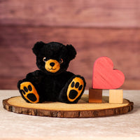 6.5 in stuffed black bear with brown paws and nose and rainbow eyes