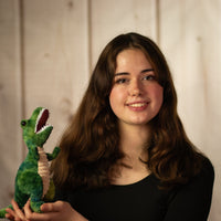 girl holding 9" green T-Rex with white teeth