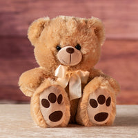 12" stuffed light brown  bear wearing a cream bow
