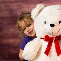 girl with 28 in white large stuffed bear wearing a red bow