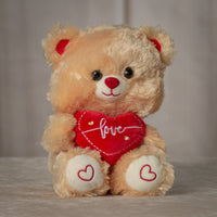 girl holding stuffed 9" tan valentines teddy bear with red love heart and red heart paws