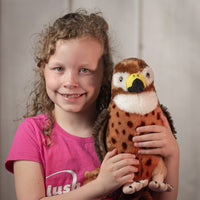 girl holding 12" stuffed Great Hawk with yellow beak and spotted chest