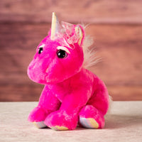 stuffed pink unicorn and eyelashes and metallic horn with a bow