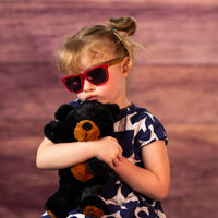 girl holding 11 in stuffed cuddly black and brown bear