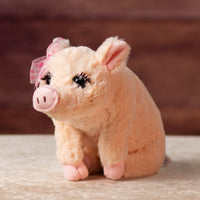 12 in stuffed pink pig wearing a bow and has eyelashes
