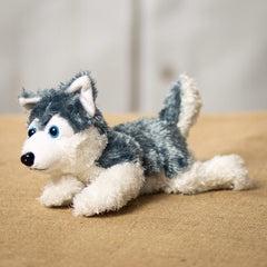 A laying grey and white laying husky that is 10 inches from head to tail