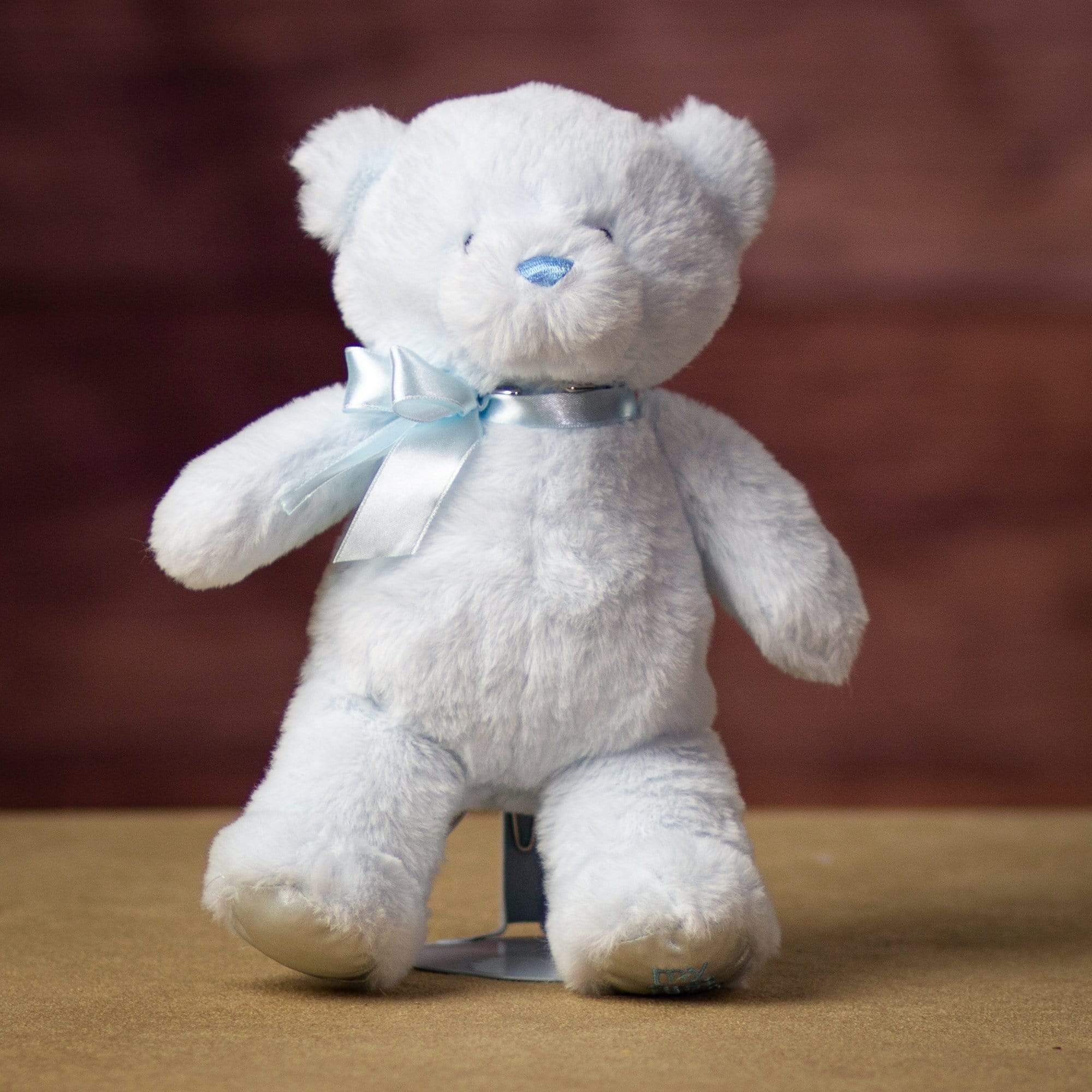 A blue bear that is 10 inches tall while standing with "My First Bear" on its left paw
