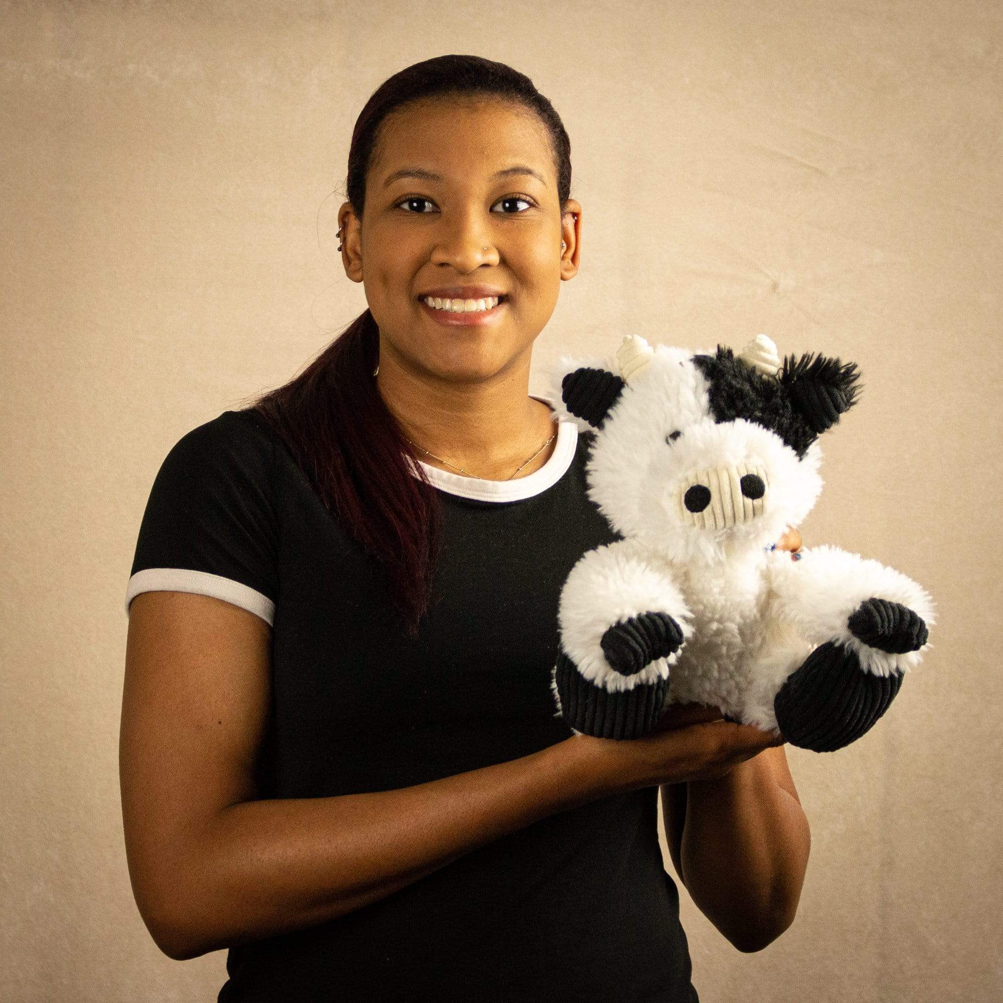 A woman holds a scruffy black and white cow that is 9.5 inches tall while sitting