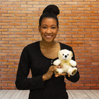 A woman holds a white bear that is 6 inches tall while sitting
