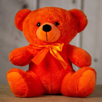 A orange bear that is 14 inches tall while sitting wearing a matching bow