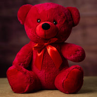 A red bear that is 14 inches tall while sitting wearing a matching bow