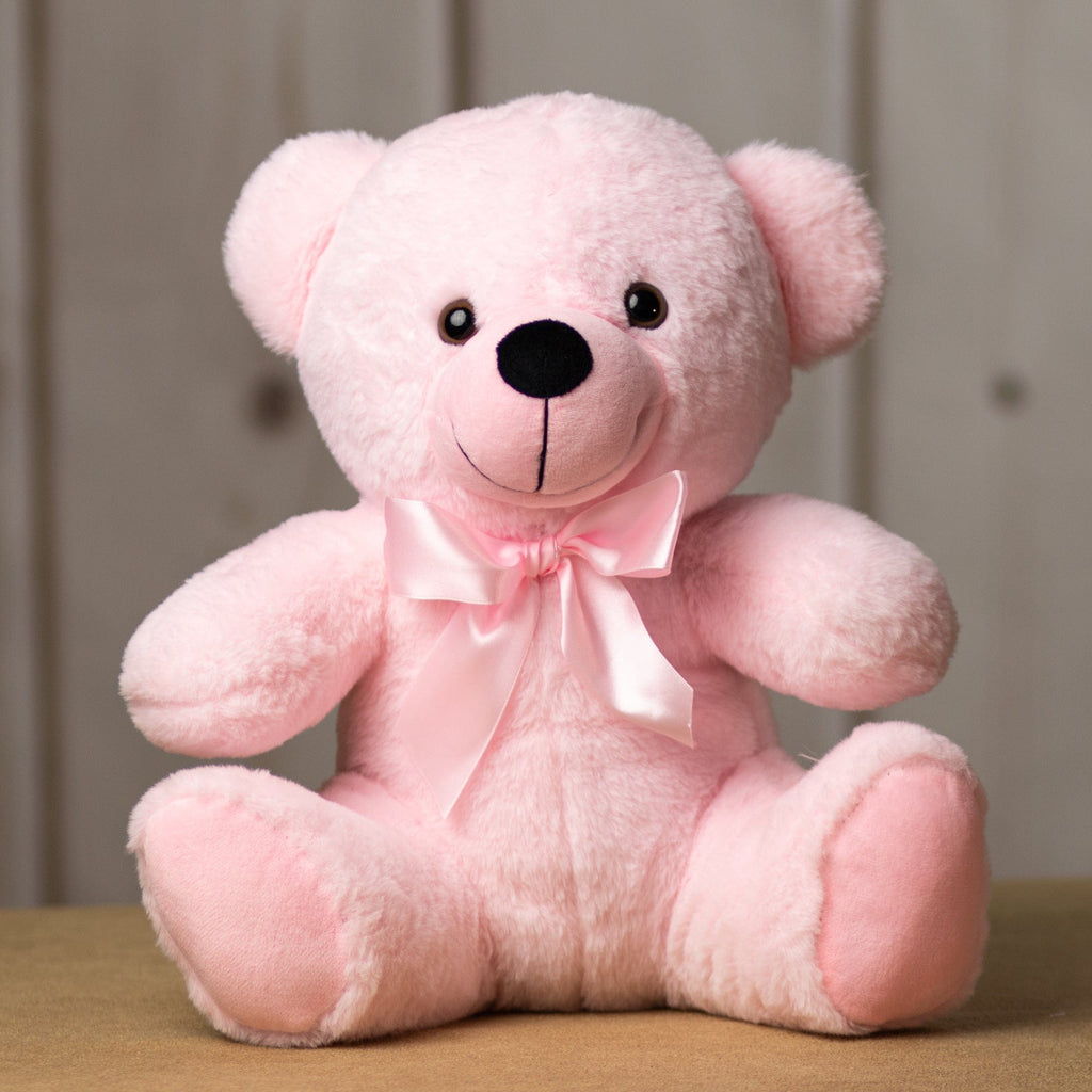 A light pink bear that is 14 inches tall while sitting wearing a matching bow