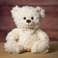 A cream bear that is 11 inches tall while sitting