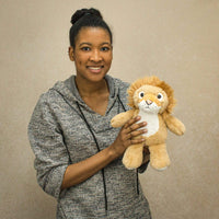A woman holds a lion that is 11 inches tall while standing
