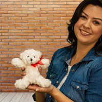 A woman holds a white bear that is 7.5 inches tall while standing
