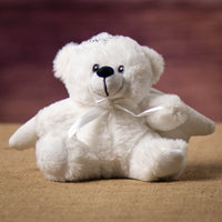 A white bear that is 6 inches tall while sitting wearing a pair of wings and a silver halo.