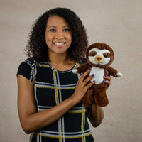 A woman holds a brown sloth that is 11 inches tall while standing