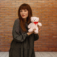 A woman holds a white bear that is 10 inches tall while standing 