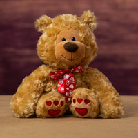 A nice looking beige valentine bear with hearts for paw prints