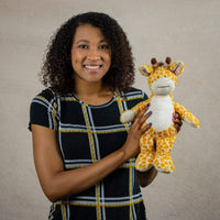 A woman holds a giraffe that is 12 inches tall while standing