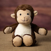 A brown monkey that is 13 inches tall while standing in a sitting position with a white belly