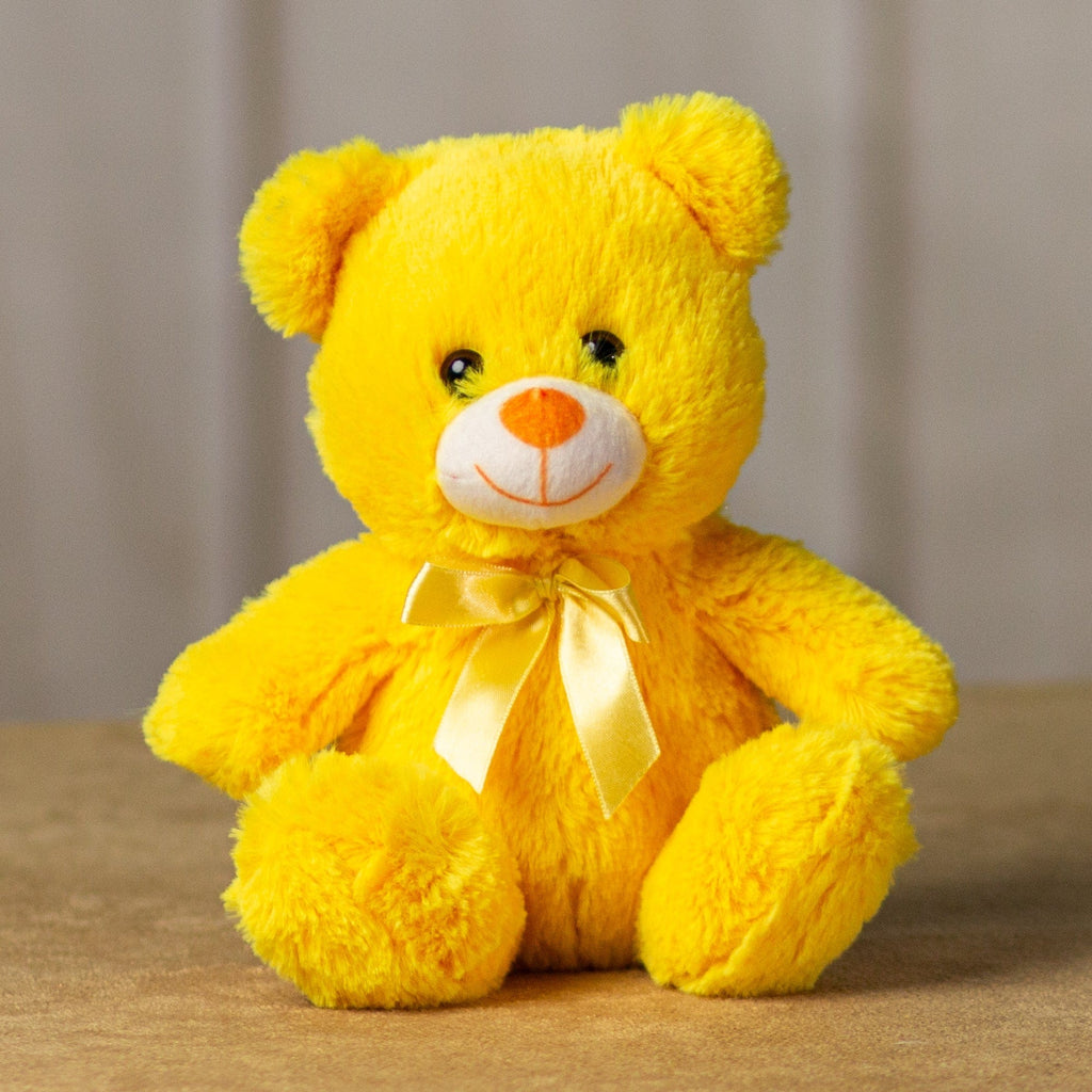 A bright yellow bear that's 7 inches tall while sitting wearing a matching bow