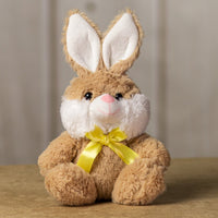 A beige rabbit that is 7 inches while sitting wearing a yellow bow