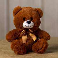 A brown bear that is 7 inches tall while sitting wearing a matching bow