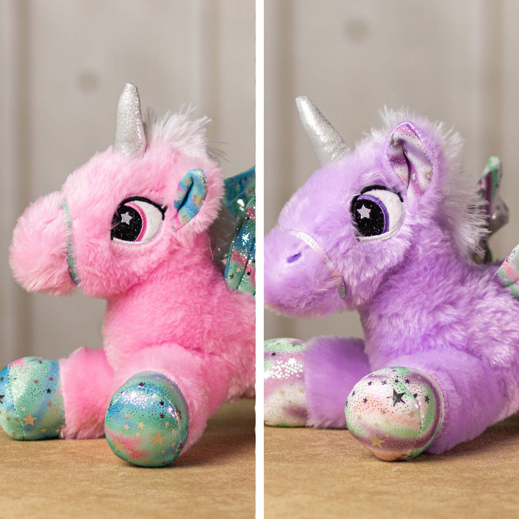 A pink and purple unicorn that are 14 inches while laying down with embroidered eyes, shiny paws, wings and horn.
