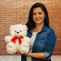 A woman holds a white bear that is 12 inches tall while sitting