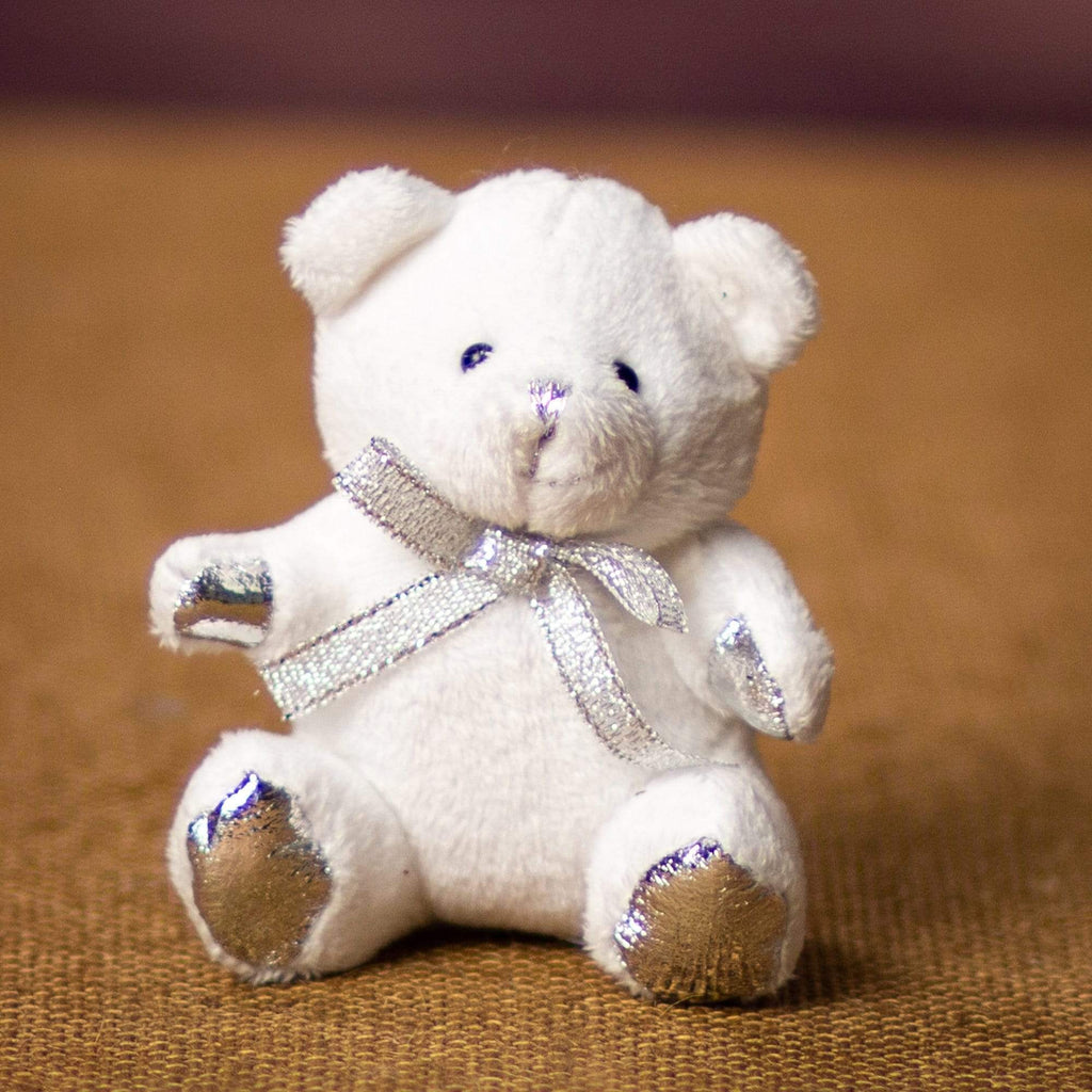 A white bear that is 3.5 inches tall while sitting with a silver bow and paws