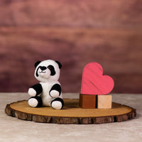 A black and white panda that is 5 inches tall while sitting next to wooden blocks